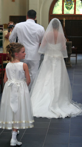 [ Down the aisle, with flower girl in tow ]