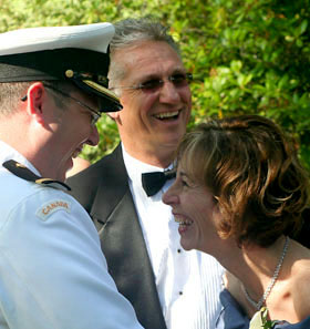 [ Groom laughs with his parents ]